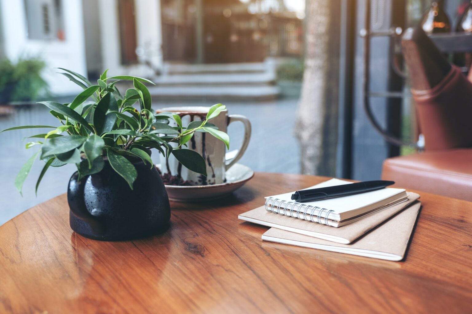 Notebooks, pen and coffee cup on wooden table