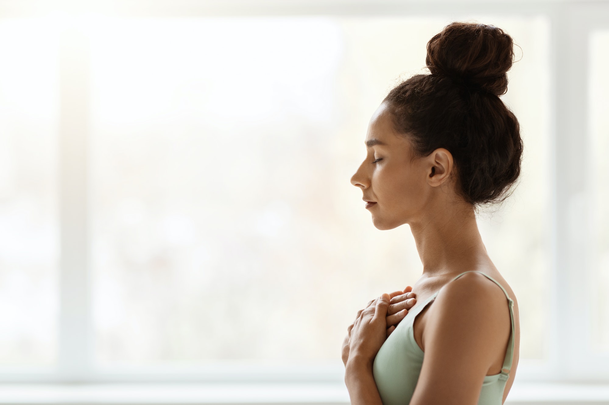 Peace Of Mind. Young Female With Hands On Chest And Closed Eyes